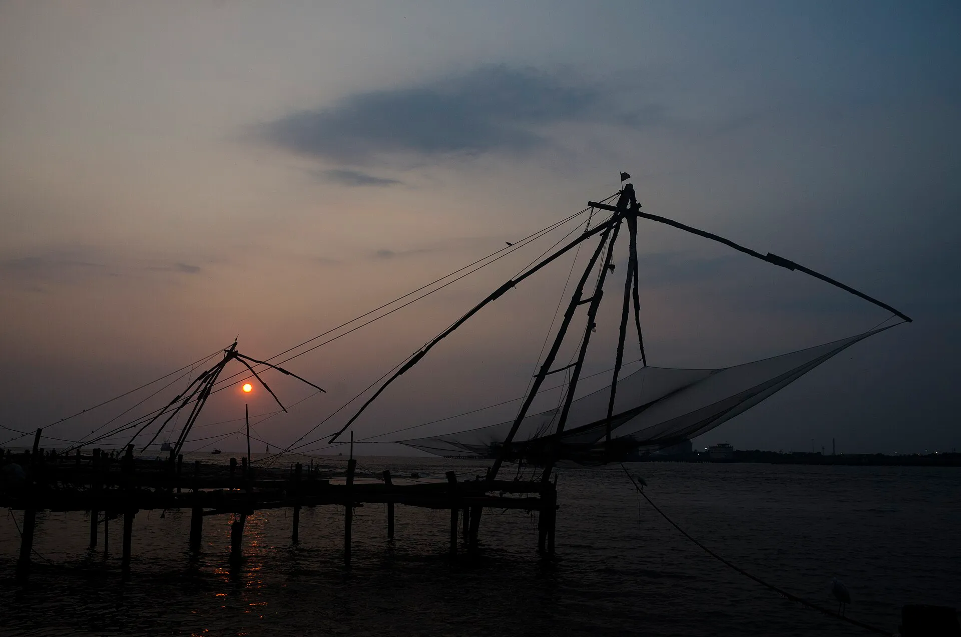 Cantilevered Chinese fishing nets silhouetted at sunset, Fort Kochi