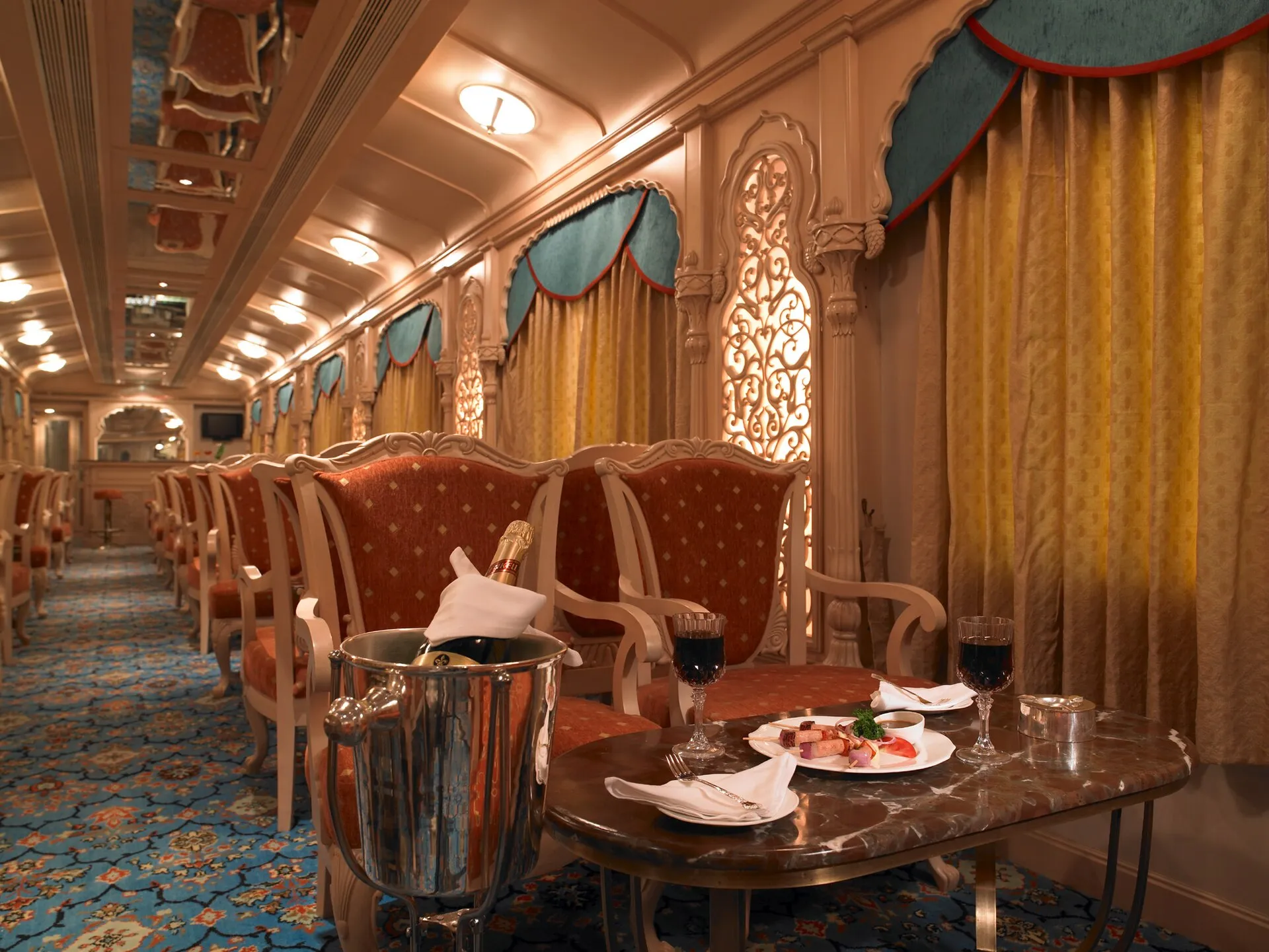 The opulent lounge car of the Golden Chariot, set with carved chairs and chilled champagne