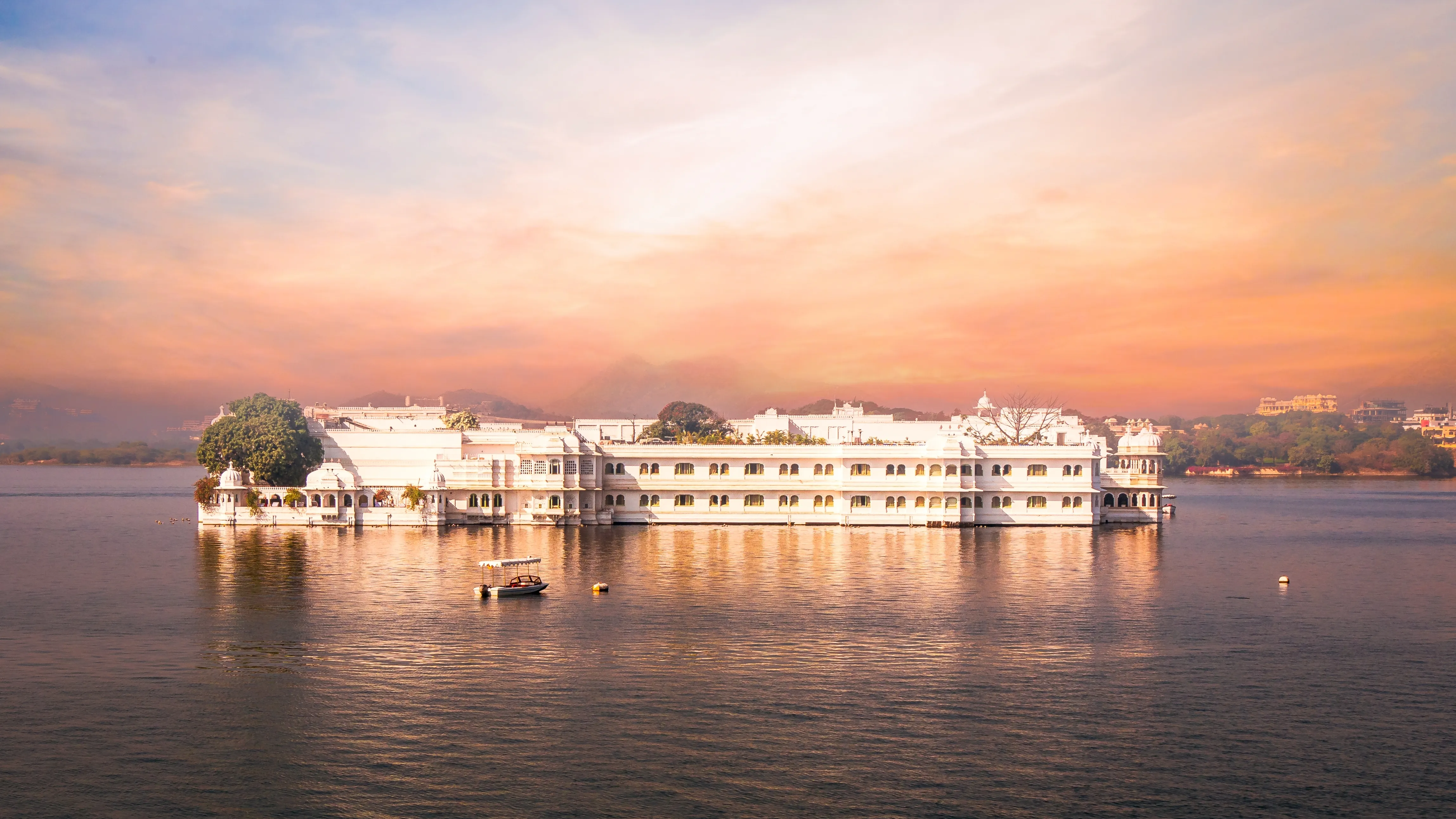 A white marble lake palace set on the water at sunset, Udaipur