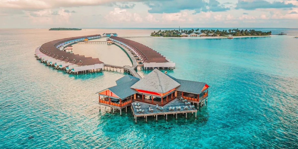 Aerial view of overwater villas above a turquoise Maldives lagoon