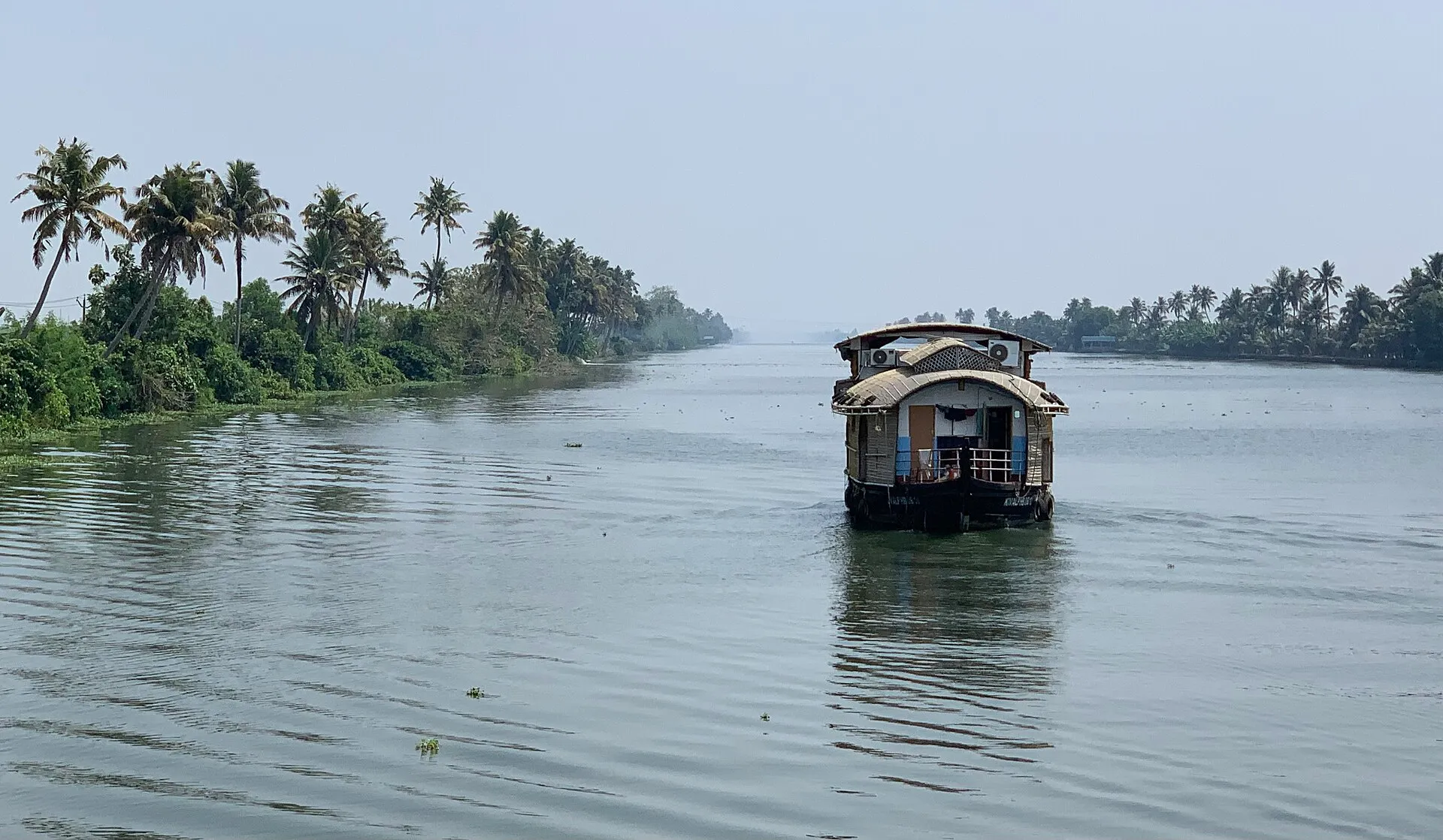 A traditional houseboat moored on the palm-fringed Alleppey backwaters in Kerala