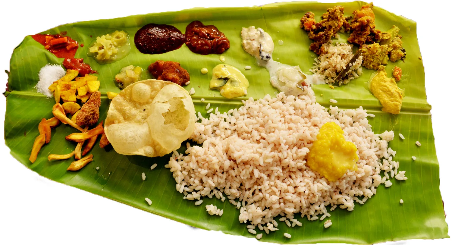 A Kerala sadhya served on a banana leaf with rice and coconut-based curries