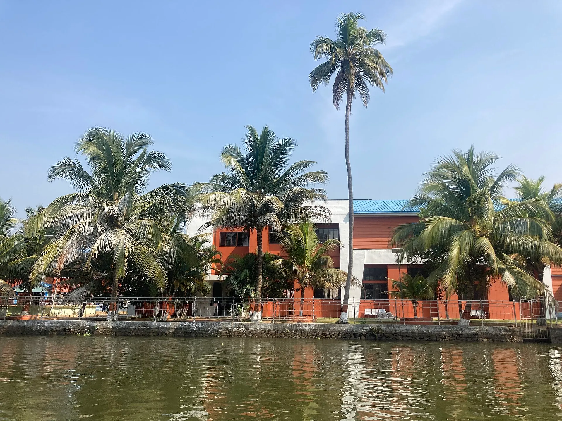 Palm-fringed backwaters at Alleppey in Kerala under a bright sky