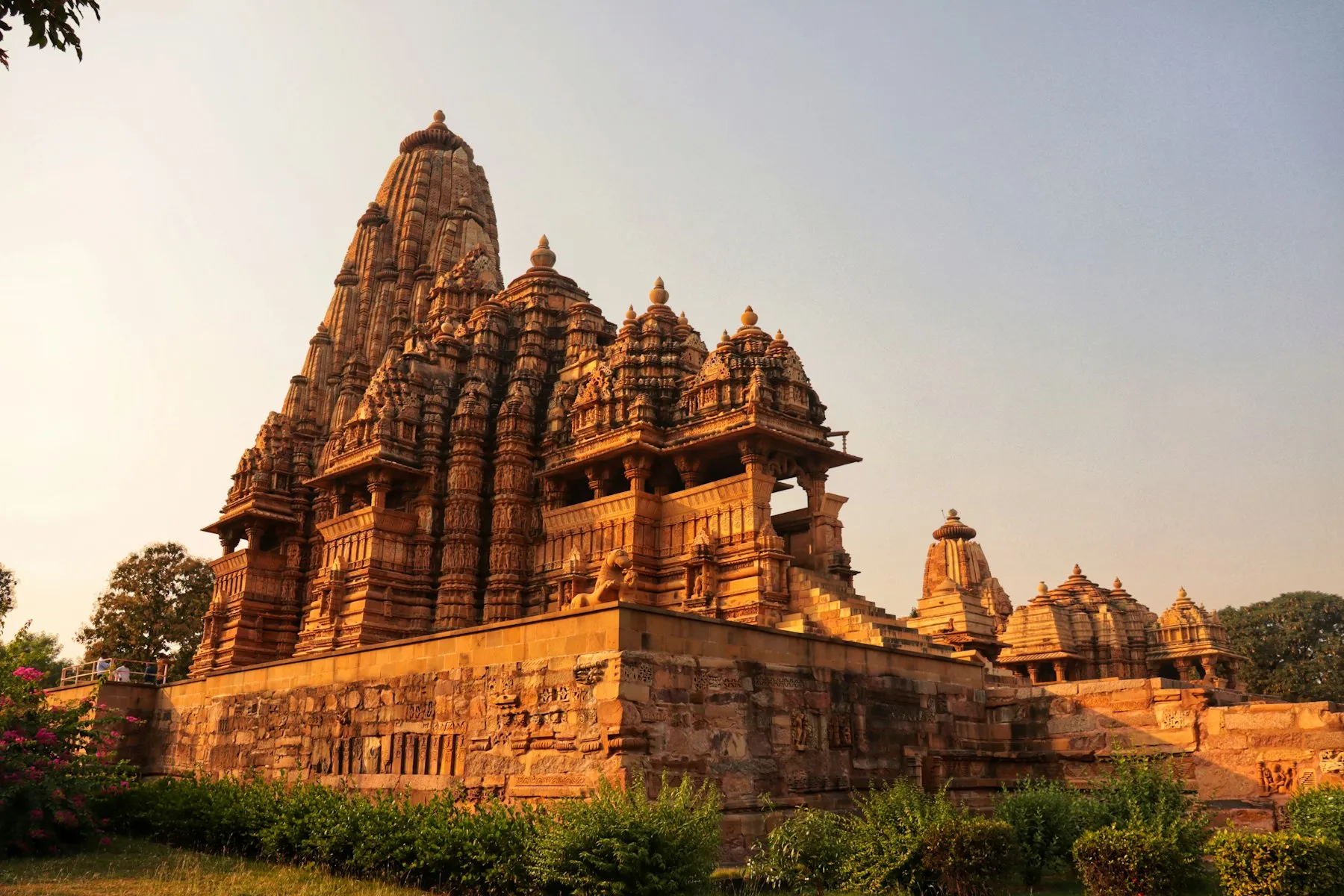 A carved sandstone shikhara of a Khajuraho temple set against an open sky