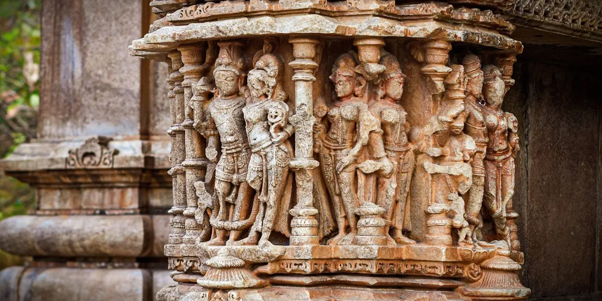 A carved sandstone shikhara of a Khajuraho temple set against an open sky