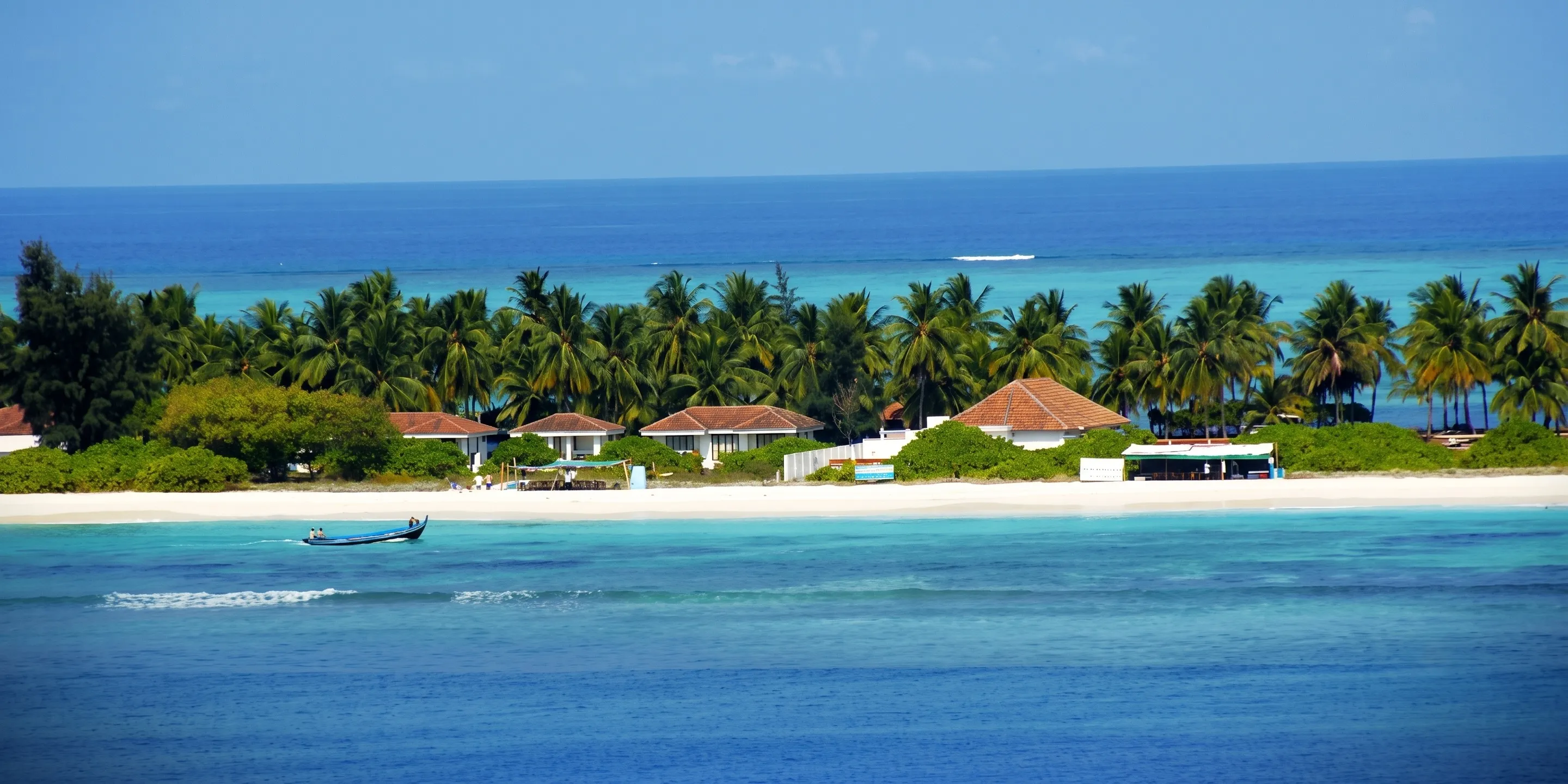 A shallow turquoise lagoon and palm-lined shore at Agatti Island, Lakshadweep