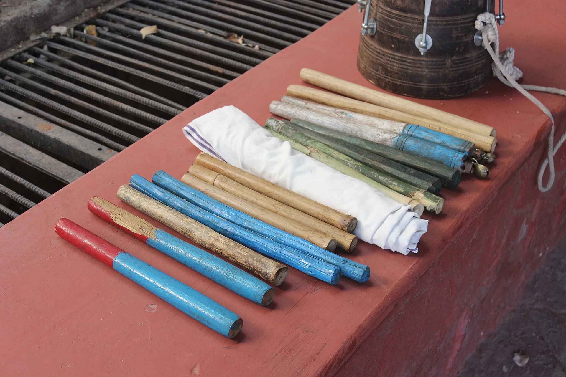 Painted wooden dance sticks and a drum laid out for a Gond tribal stick dance in central India