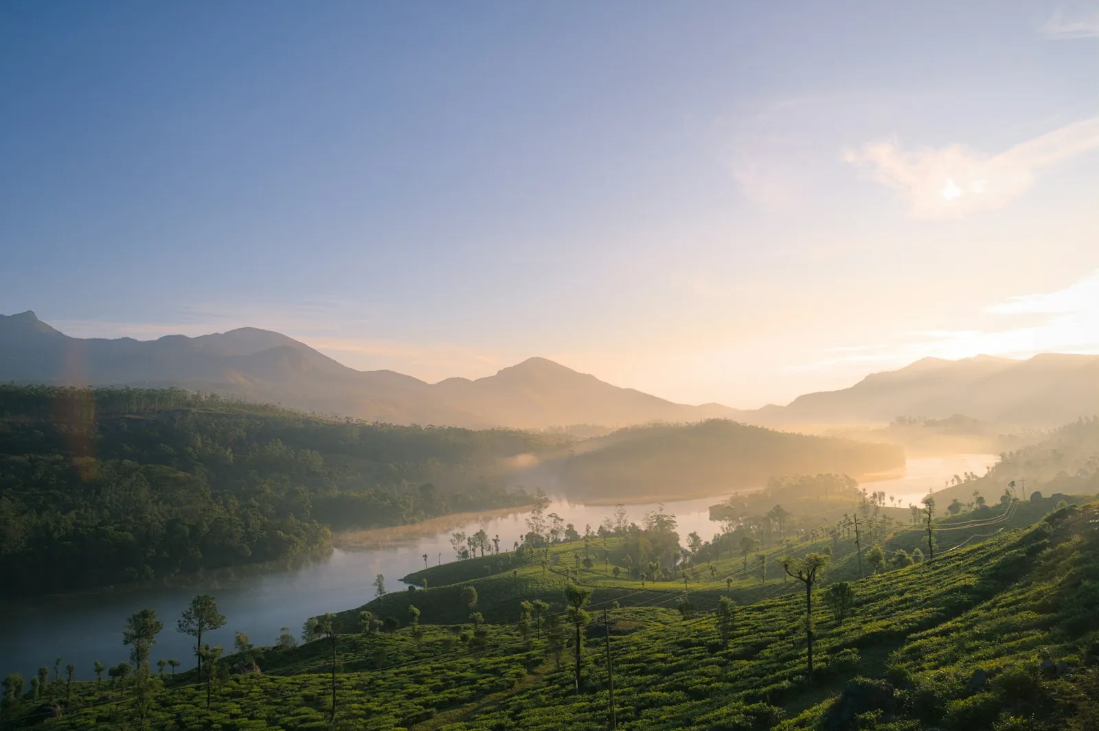 Golden dawn mist over layered mountains and a winding river