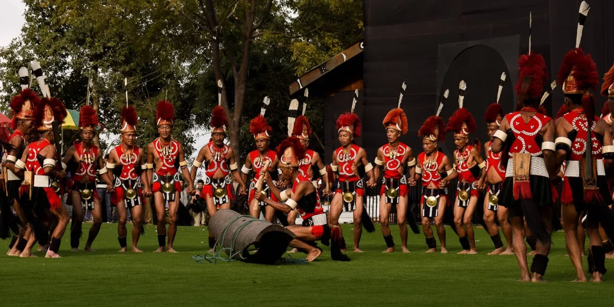 The horned-gable main stage of the Hornbill Festival in Nagaland with festival-goers on the green
