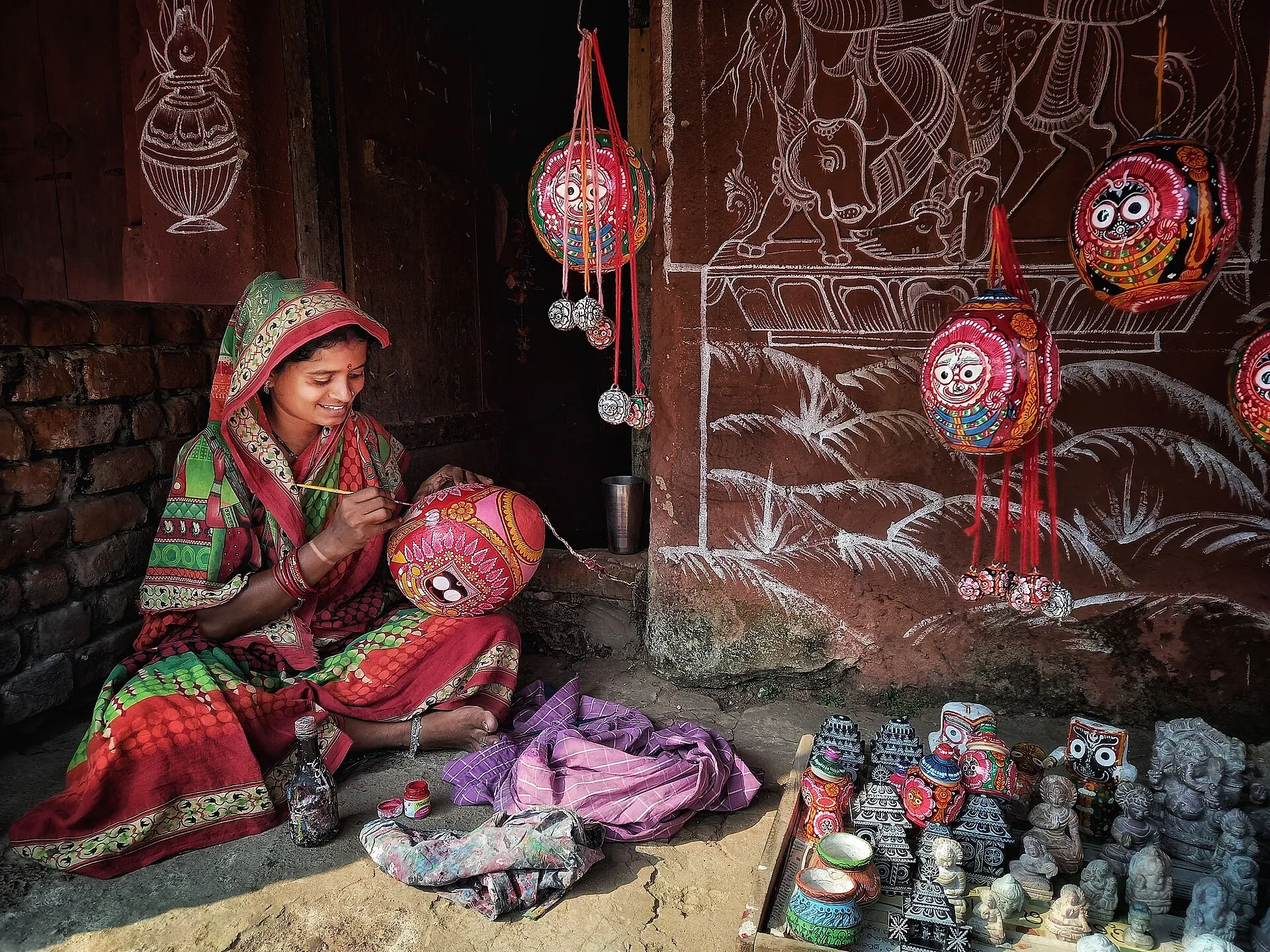 A Pattachitra artist painting a detailed scroll at work in Odisha