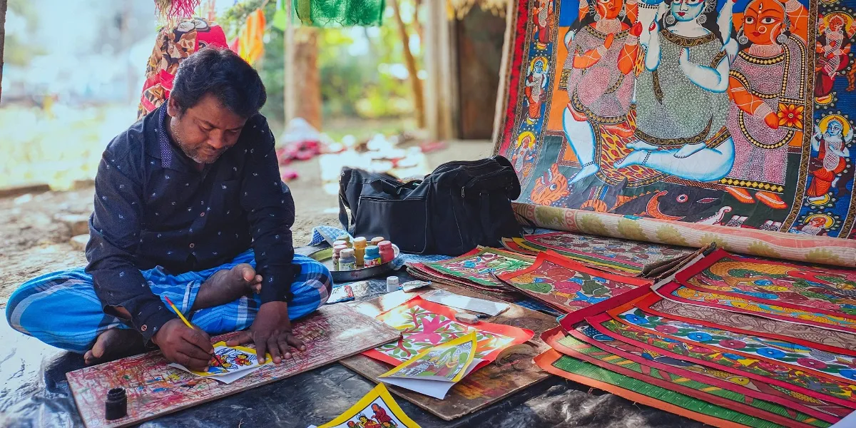 A Pattachitra artist painting a detailed scroll at work in Odisha