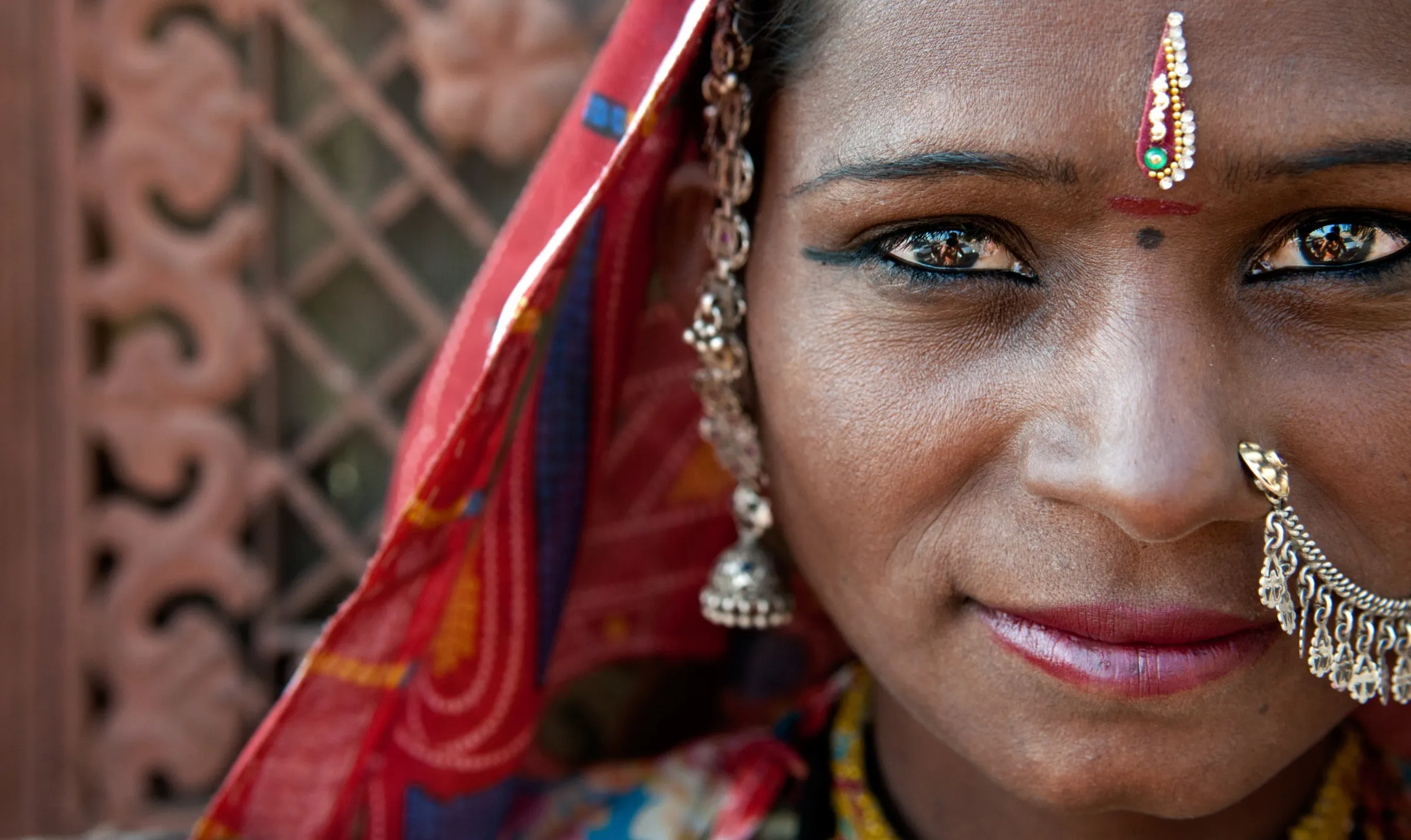 Portrait of a Rajasthani woman in a red veil with traditional jewellery