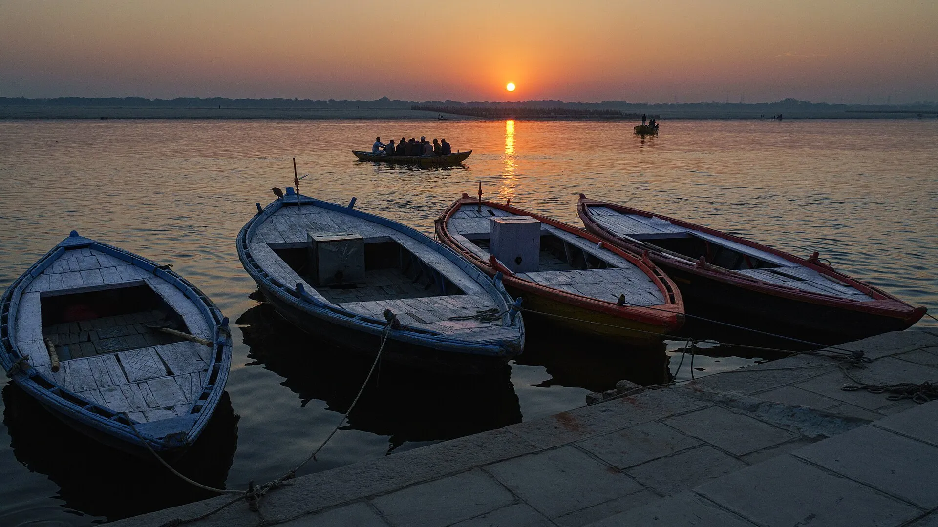 Wooden boats on the Ganges at sunrise before the ghats of Varanasi