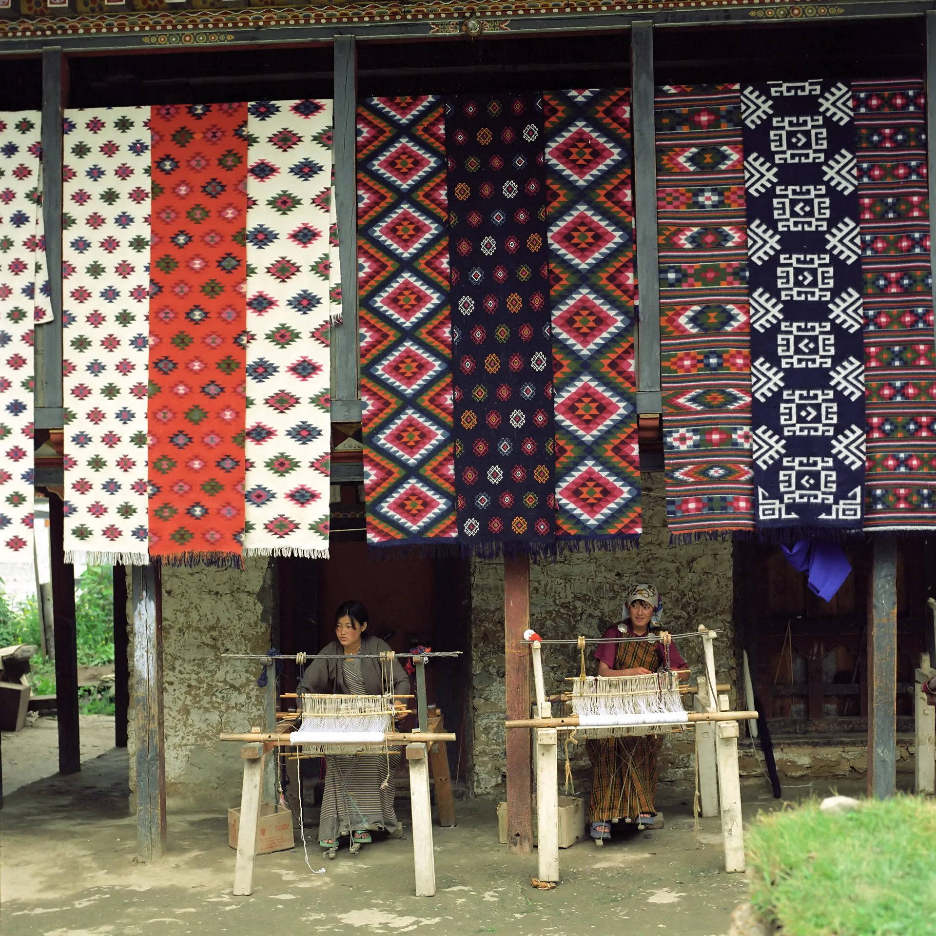 Brightly coloured handwoven Bhutanese yathra textile on a traditional loom